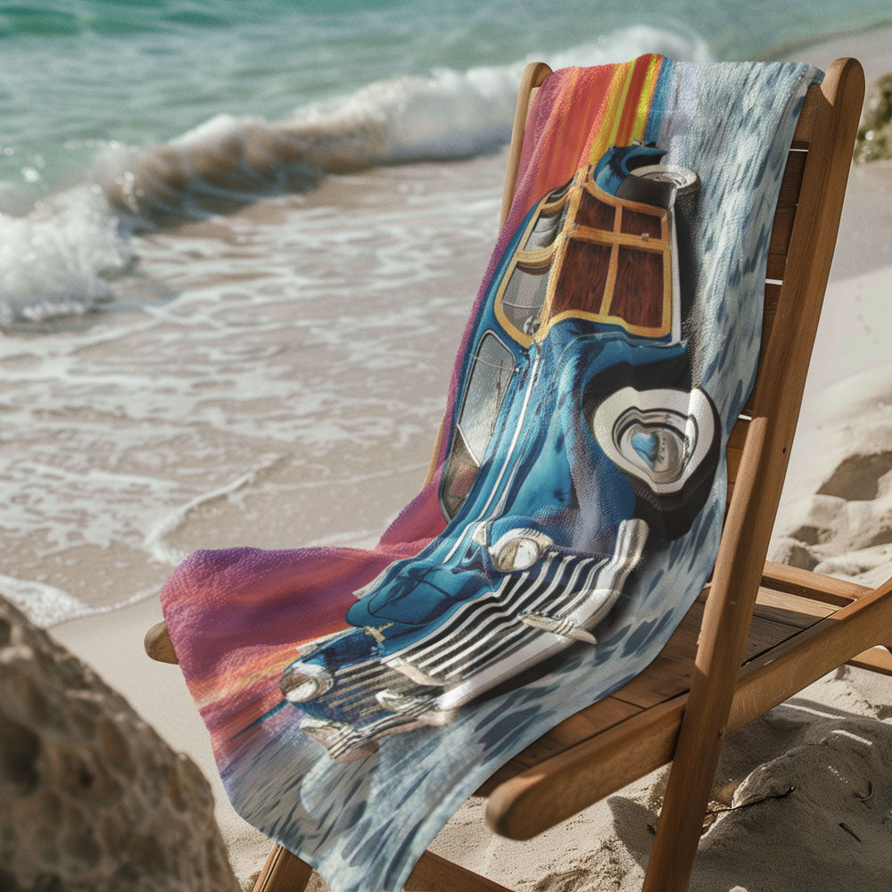 Classic Car Beach Towel laying over a wooden deck chair on the beach next to the edge of the waves