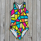 Multicolored geometric patterned swimsuit on a rustic nautical wood background