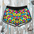 Colorful geometric patterned shorts worn by a person on a rustic nautical wood background