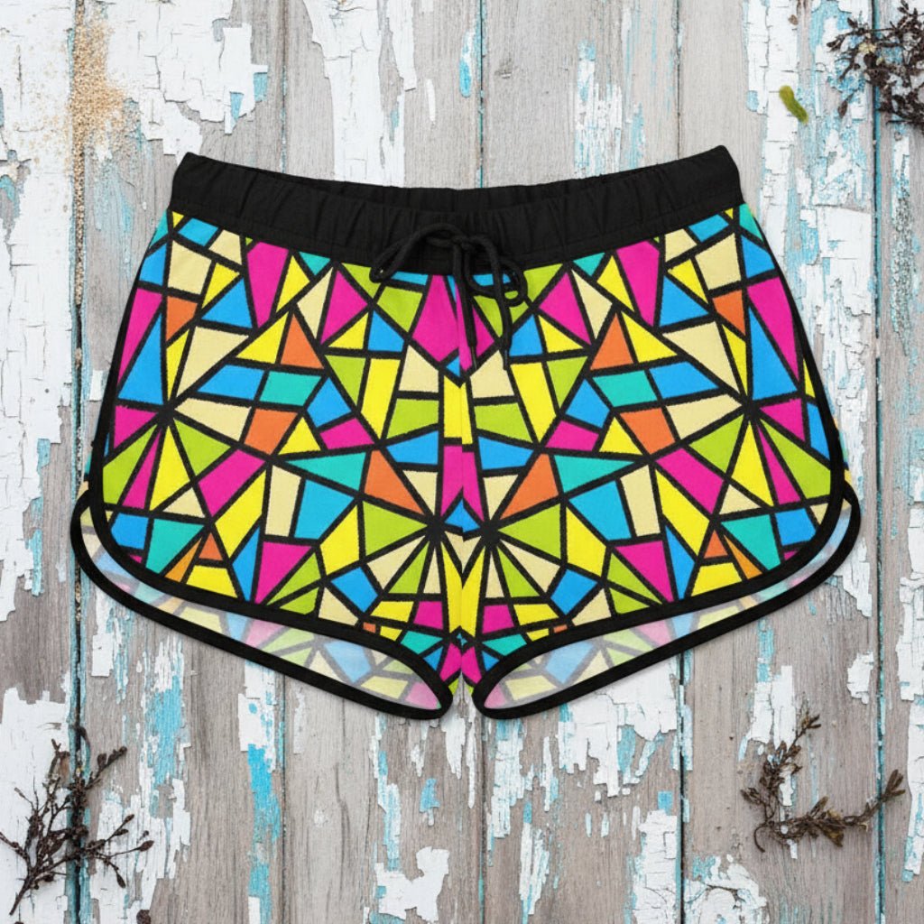 Colorful geometric patterned shorts worn by a person on a rustic nautical wood background