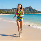 Woman wearing a colorful geometric patterned swimsuit running on the beach in Waikiki with Diamond Head Mountain in the background