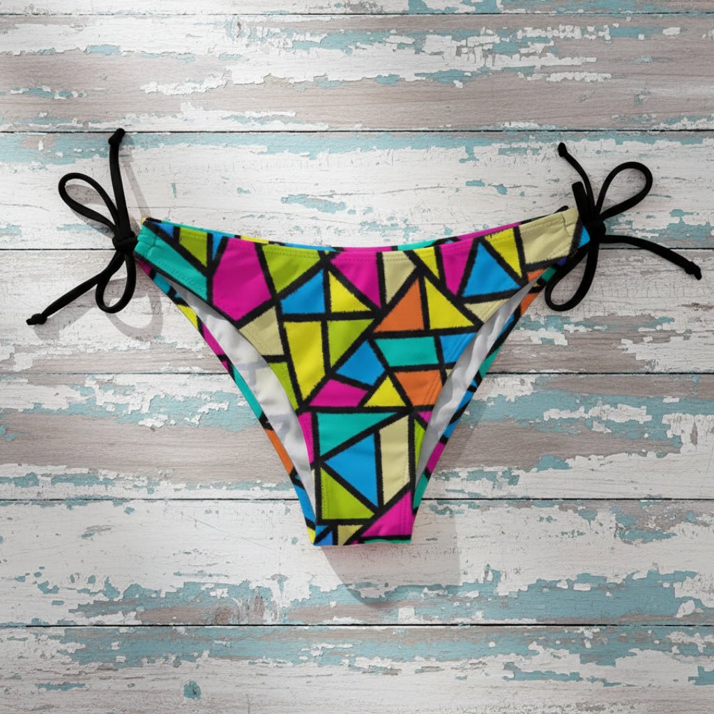 Colorful abstract pop art-patterned bikini bottom on a rustic wood background