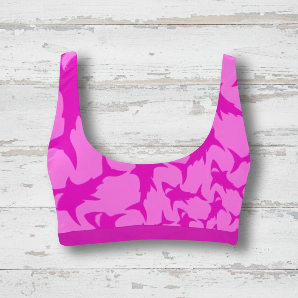 Pink shark pattern sports bra bikini top on a rustic wood background