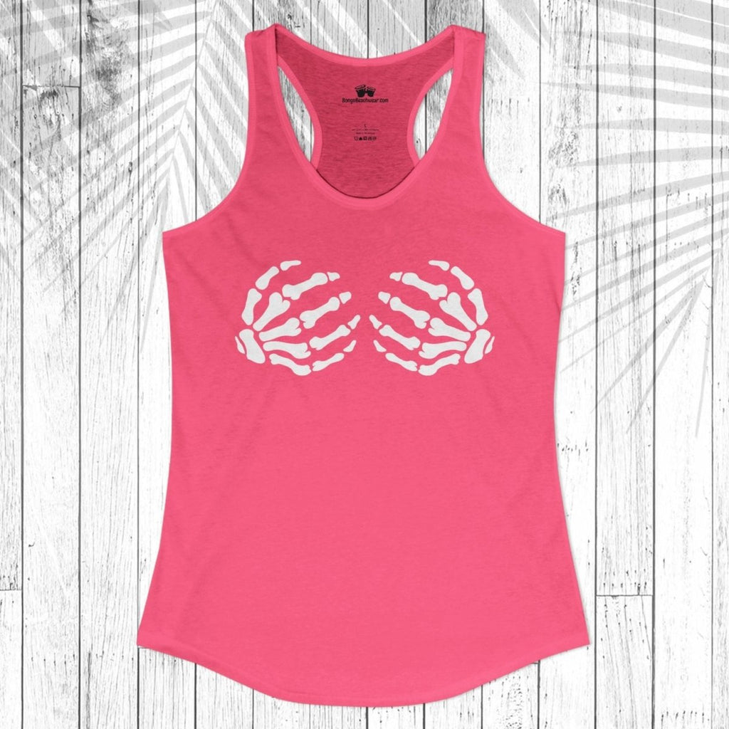 A bright pink racerback tank top with a white graphic of two skeletal hands forming a heart shape on the chest, displayed flat against a white wood plank background with a palm leaf overlay.