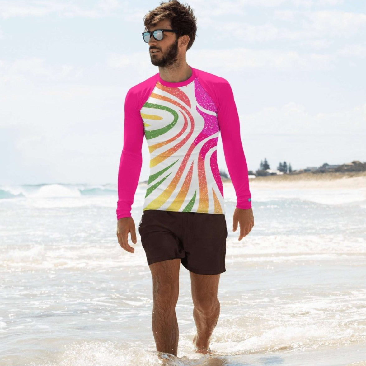 Man wearing a colorful long-sleeve swimming shirt and sunglasses on a beach