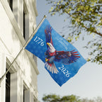 Flag with eagle design and text on a building with trees in the background