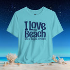 A light aqua blue graphic t-shirt displayed on a beach scene background. The shirt features the text 'I Love The Beach and 2 maybe 3 People' printed in dark navy blue.
