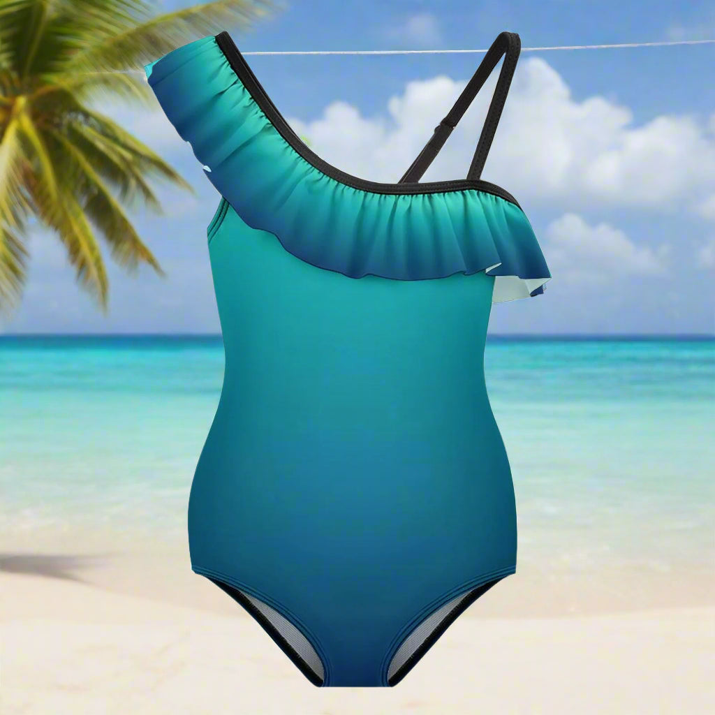 Aqua Blue ombre one-piece swimsuit with ruffled shoulder design hanging on a line in a beach island paradise
