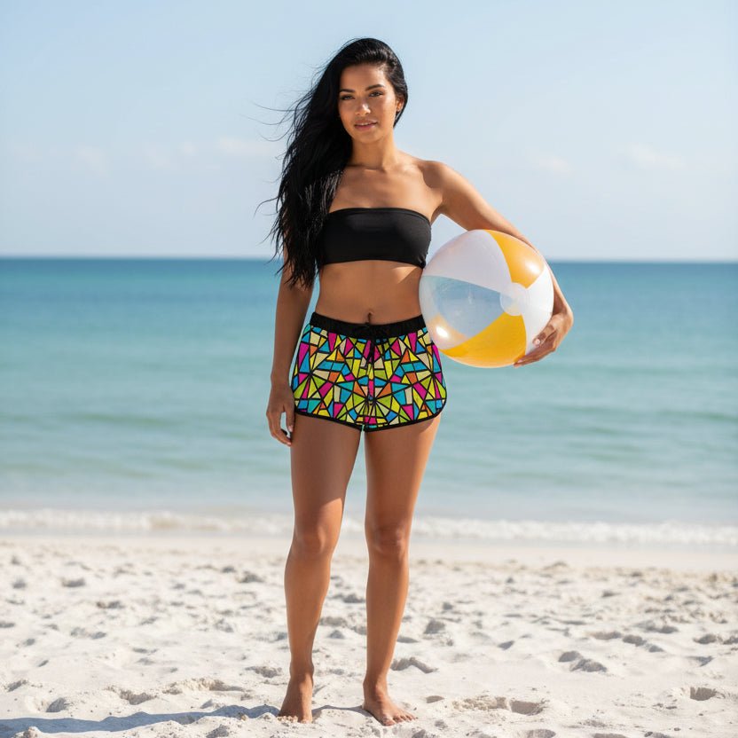 Beautiful woman with long flowing black hair wearing Colorful Swimsuit Cover Shorts and a black tube top and holding a beach ball at her side standing on st pete beach florida