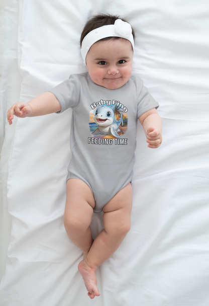 Baby wearing a gray onesie with a cartoon baby shark and text, lying on a white blanket.