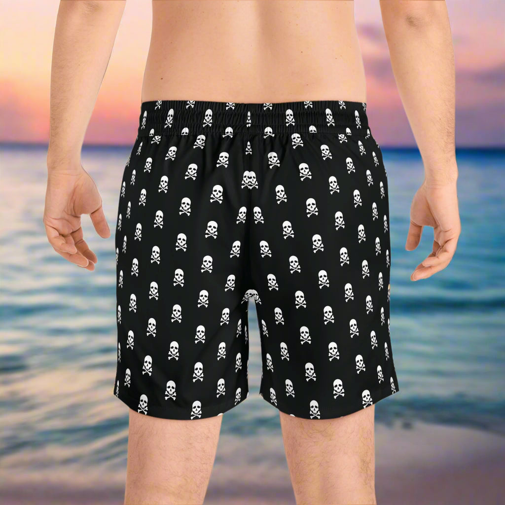 Mens board shorts backside on a guy standing on the beach waiting for the tide to roll in