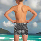 Person wearing black and white pirate skull-patterned swim shorts looking out over the Caribbean from a beach in St. Thomas