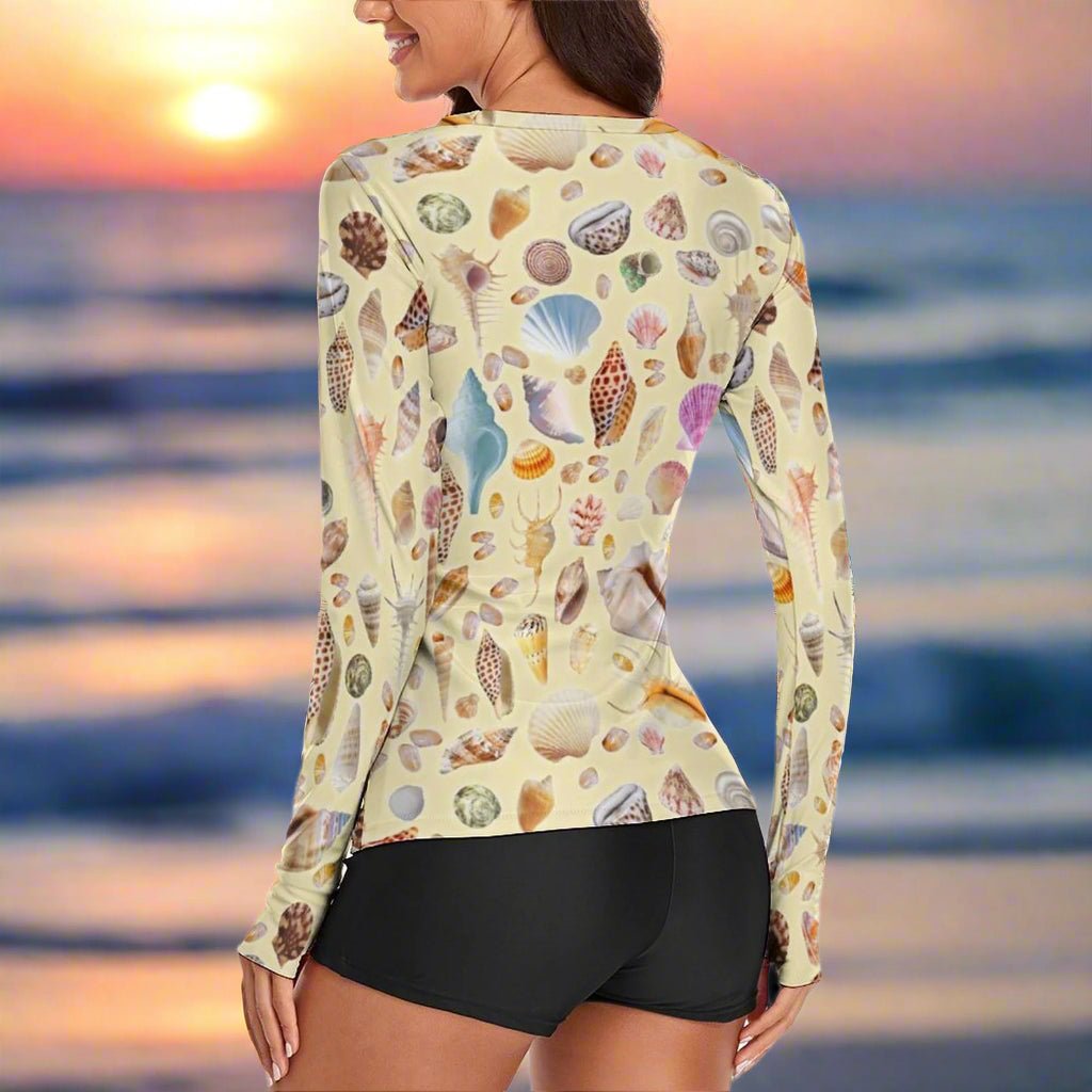Woman wearing a long-sleeve shirt with shell pattern and black shorts on a Beach background