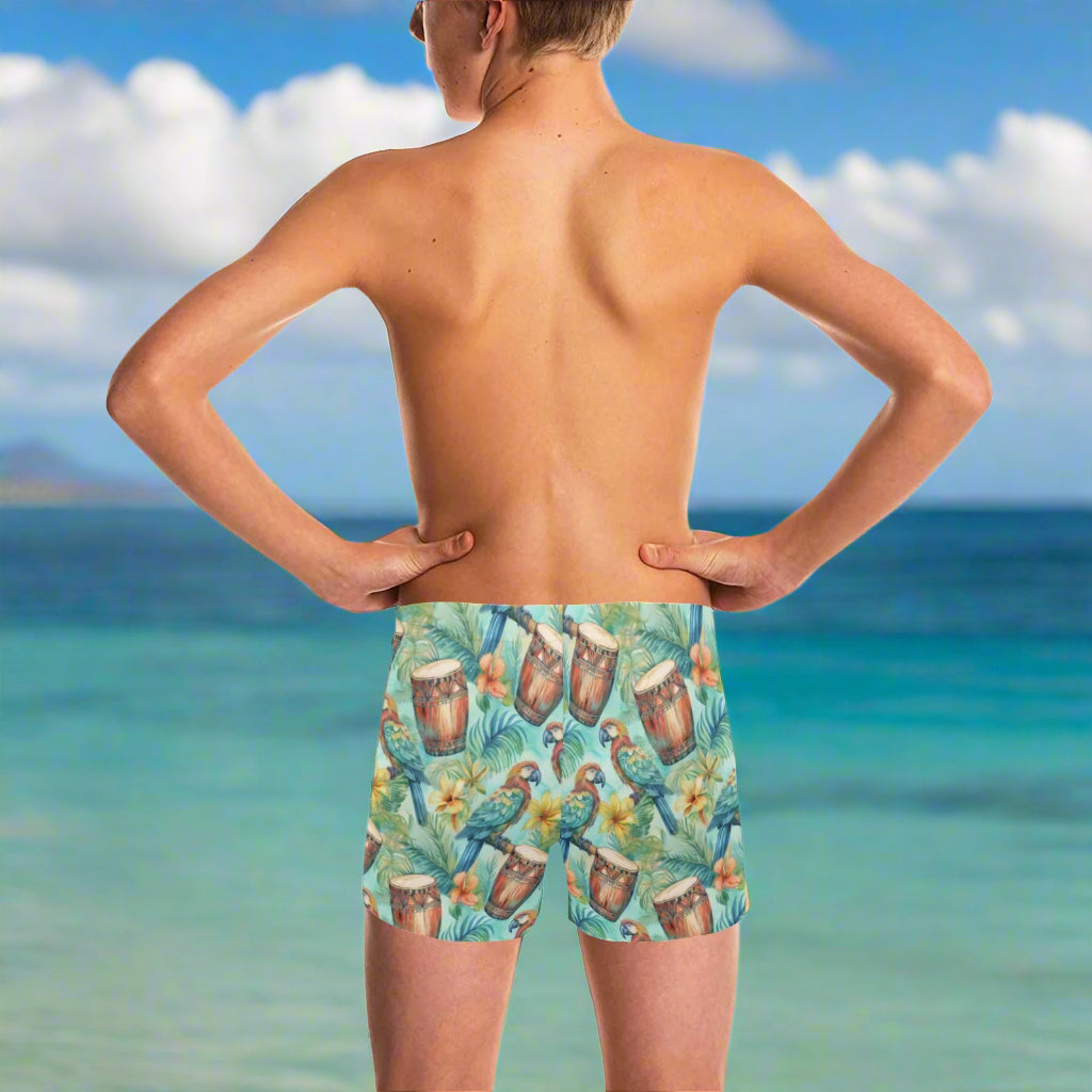 Dude wearing colorful tropical-themed swim shorts looking out over the ocean in Waikiki