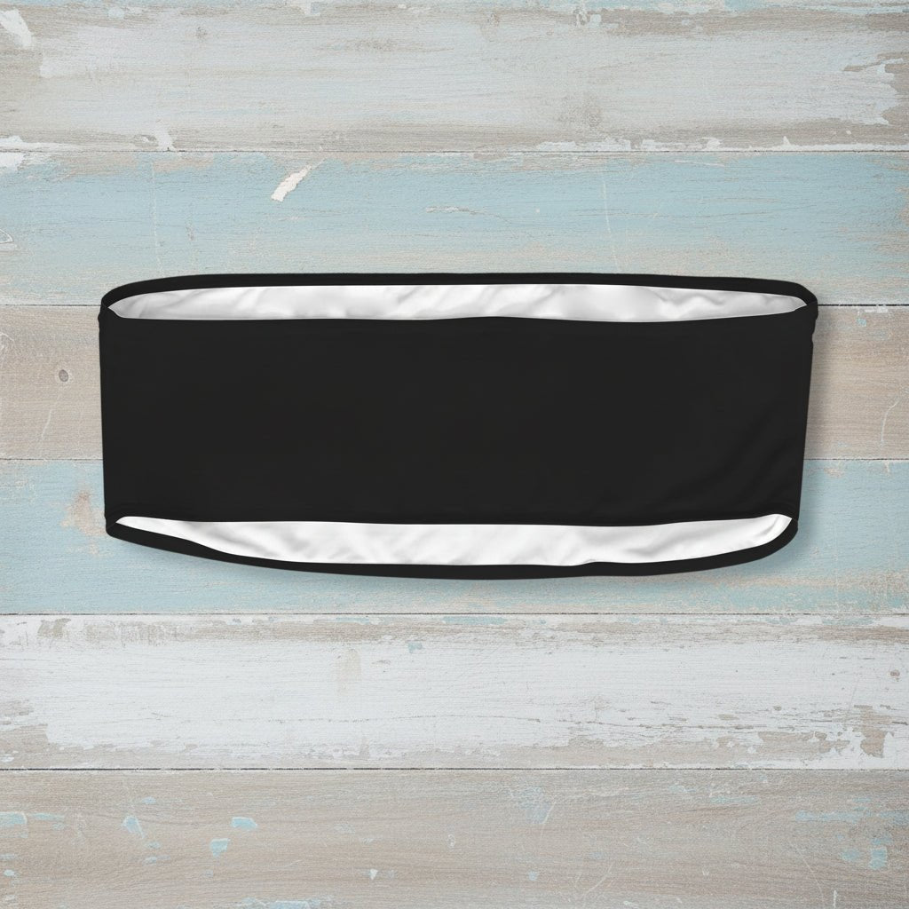 Black headband with white skull and crossbones pattern on a faded wood background