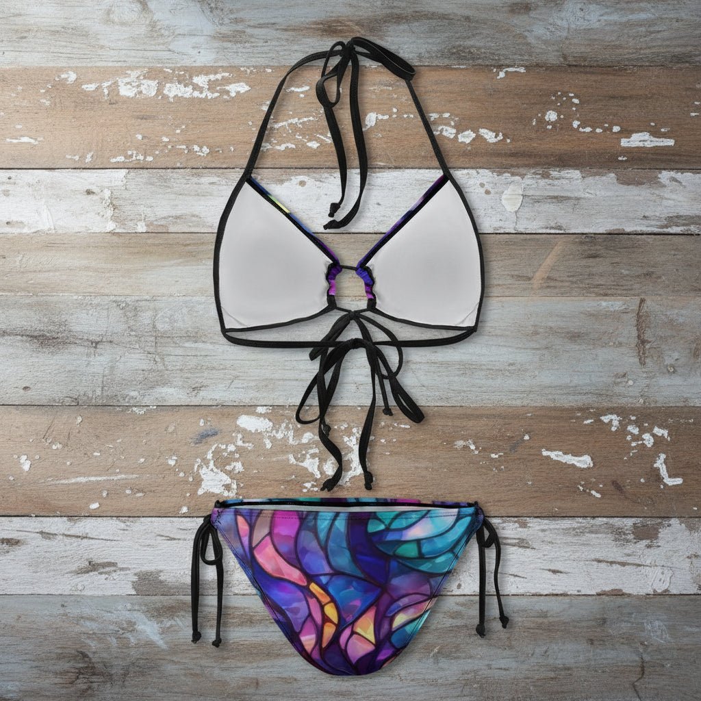 Bikini set with a colorful stained glass-style top and bottom on a rustic wood background