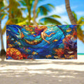 Beautiful stained-glass style art on be large beach towel hanging on a line between palm trees on a tropical island beach 