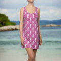 swimwear model in hot pink tank top dress adorned with a fun seahorse pattern. standing on a beach of some faraway island.