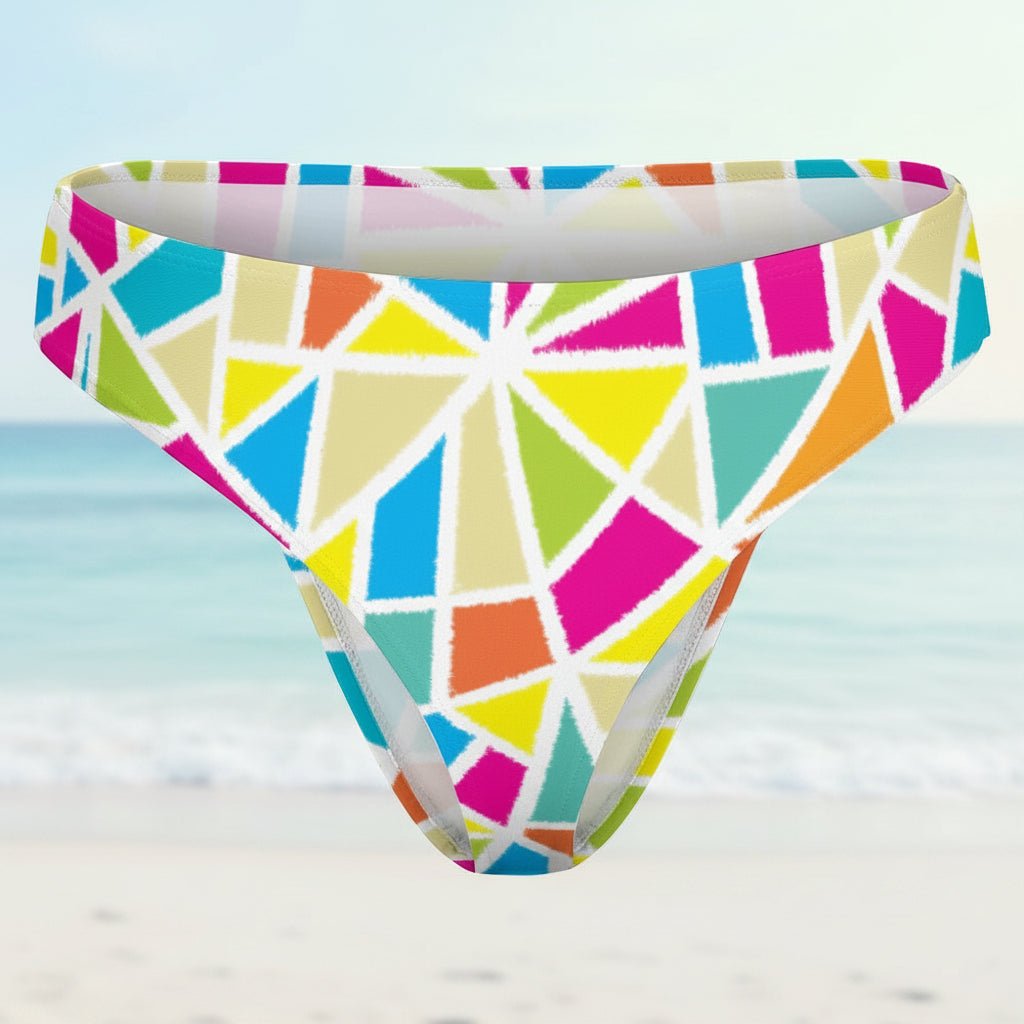 Colorful geometric patterned bikini bottom on a faded beach background