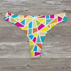 Colorful geometric patterned bikini bottom on a rustic wood background