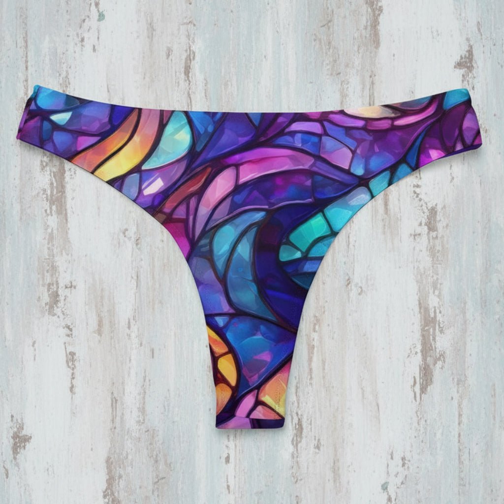 Colorful stained glass patterned bikini bottoms on a rustic wood background