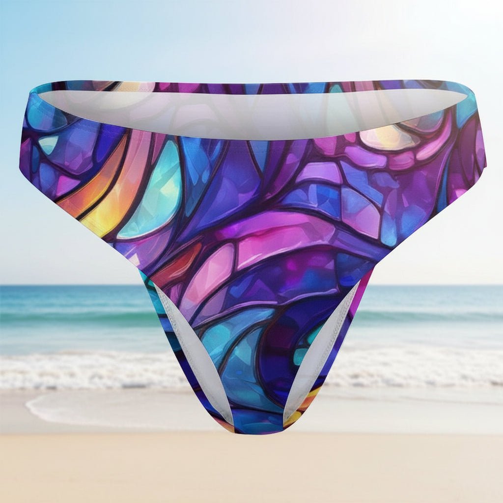Colorful stained glass patterned swim briefs on a faded beach background