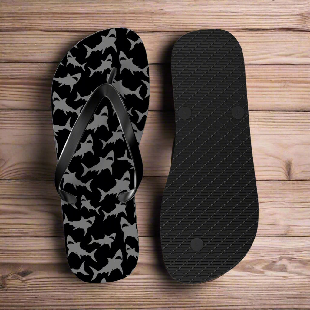 Black and gray patterned flip-flop sandal with a sole view on a nautical wood background