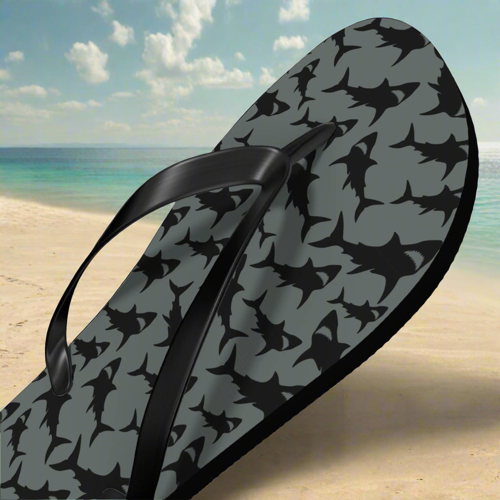 Flip-flop with shark pattern on a beach background