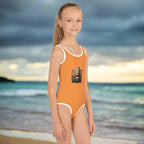 Girl in One Piece tiki style swimsuit standing on beach in Hawaii