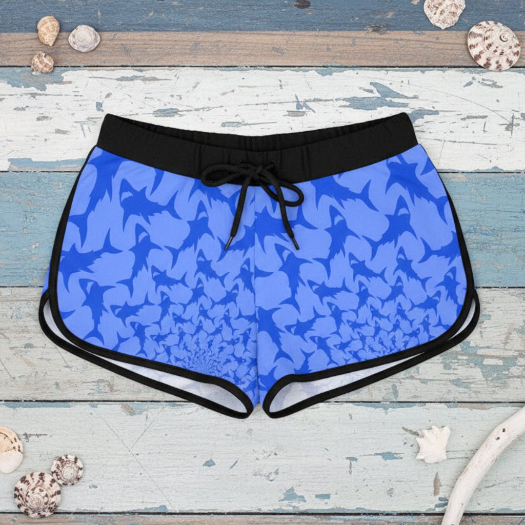 Blue shark patterned bikini shorts with black waistband on a rustic wood background