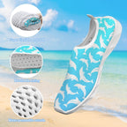 A single slip-on water shoe with a turquoise blue and white dolphin print, shown against a beach background with three circular inset detail callouts highlighting its soft flexible material, breathable lining, and water-permeable outsole.