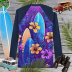 Navy blue rash guard with tropical floral design on a wooden background with surfboards and vintage cars.