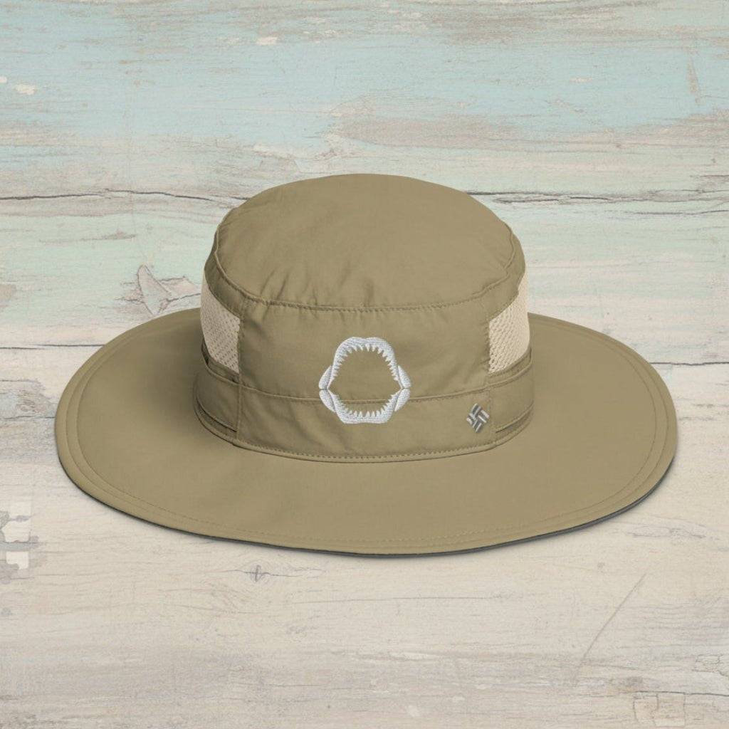Khaki wide-brimmed hat with shark jaw embroidery on a faded wood background 