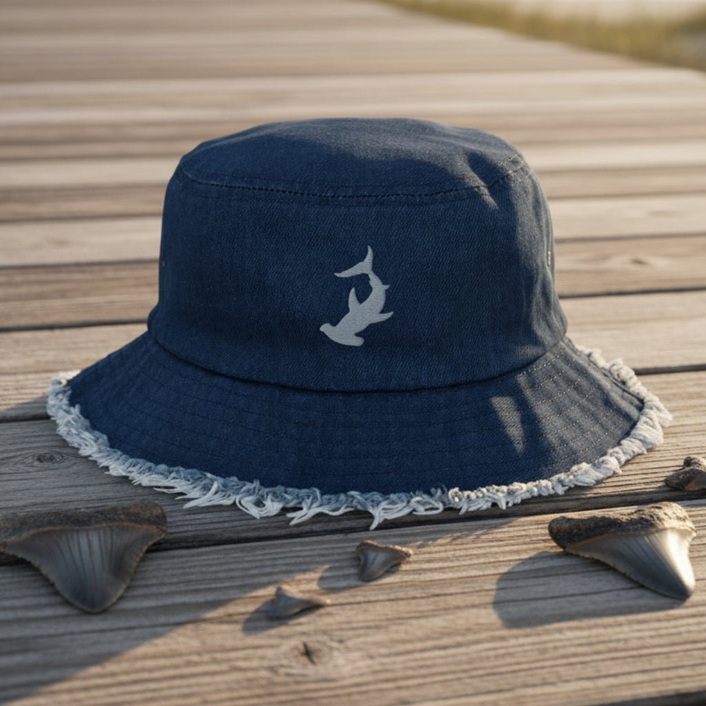 Navy blue bucket hat with a Hammerhead Shark embroidery on a beachside boardwalk