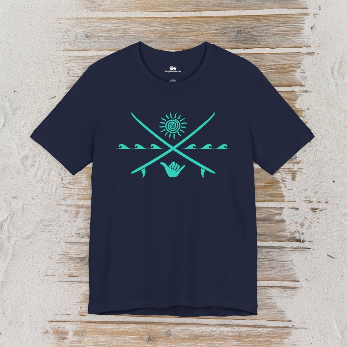 A navy blue short-sleeve t-shirt with a turquoise graphic of crossed fishing rods, a sun, and a hand holding a phone, displayed flat on a light wood plank background.