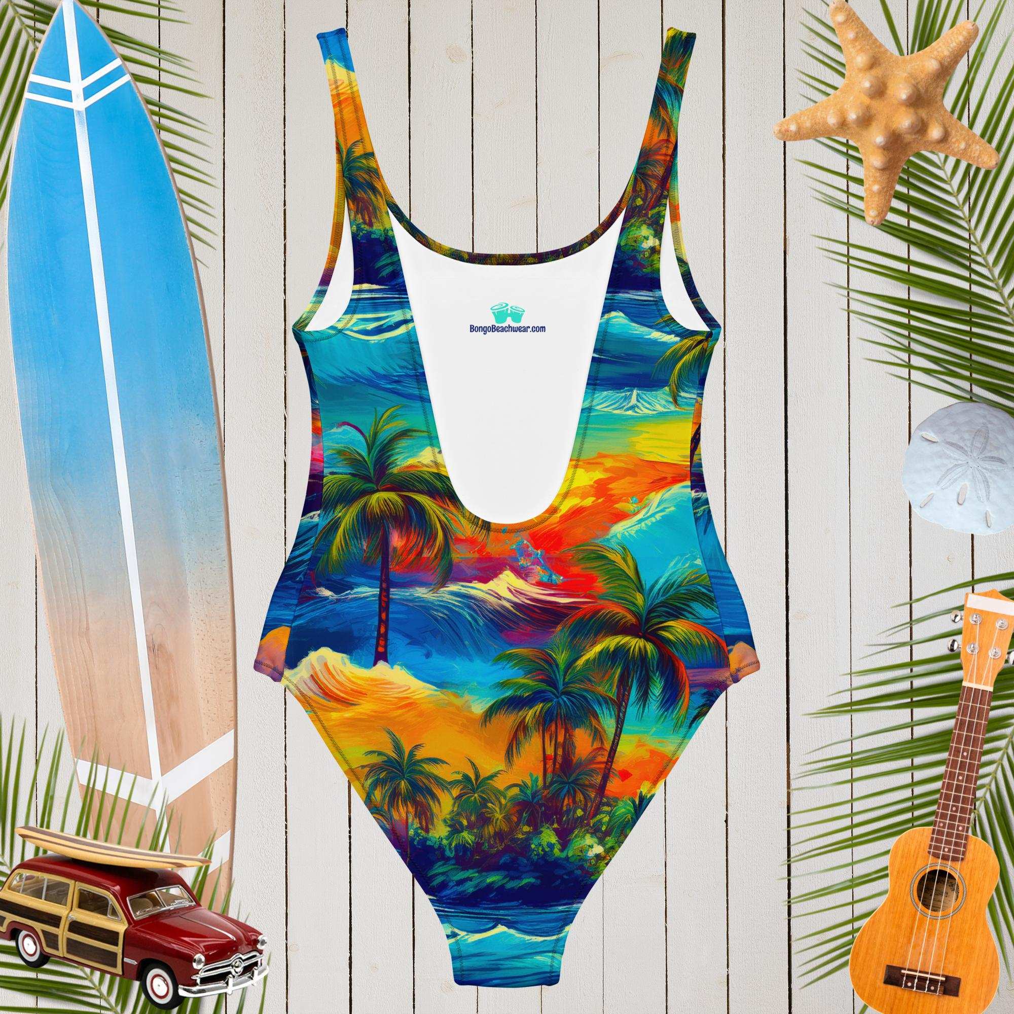 Vibrant Hawaiian print one-piece women's swimsuit with a scoop neckline and beach accessories in the background.