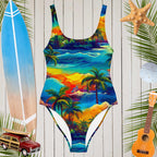 Vibrant Hawaiian print women's one-piece swimsuit on a beach-themed background with surfboard and tropical decor.