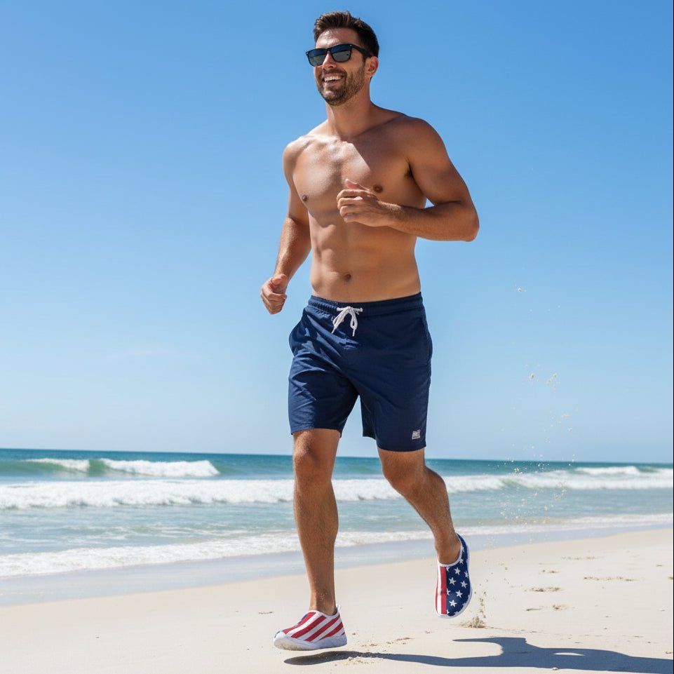 Cool dude jogging in USA Flag pattern shoes, navy board shorts and sunglasses on clearwater beach usa