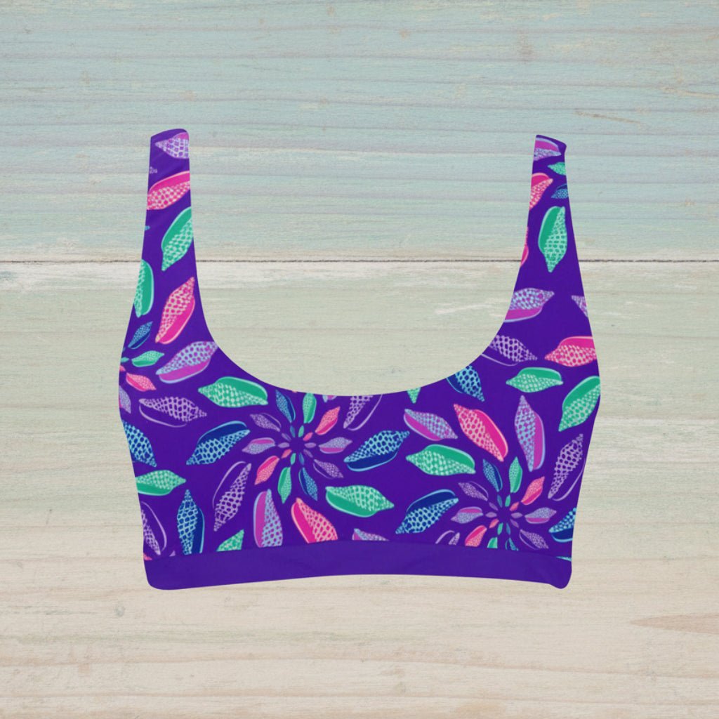 Purple bikini top with colorful seashell pattern on a nautical wood background