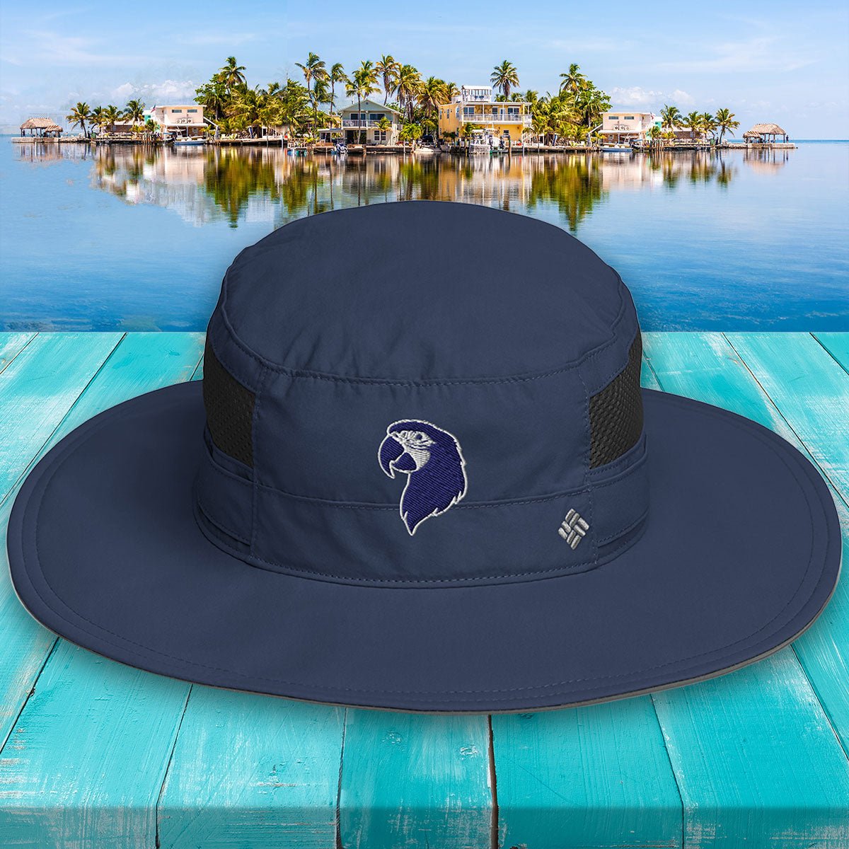 Navy blue wide-brimmed Parrot Head Booney Hat with a logo on a wooden surface with a scenic background