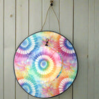 Colorful tie-dye bucket hat hanging by its drawstring chinstrap on a nautical wall