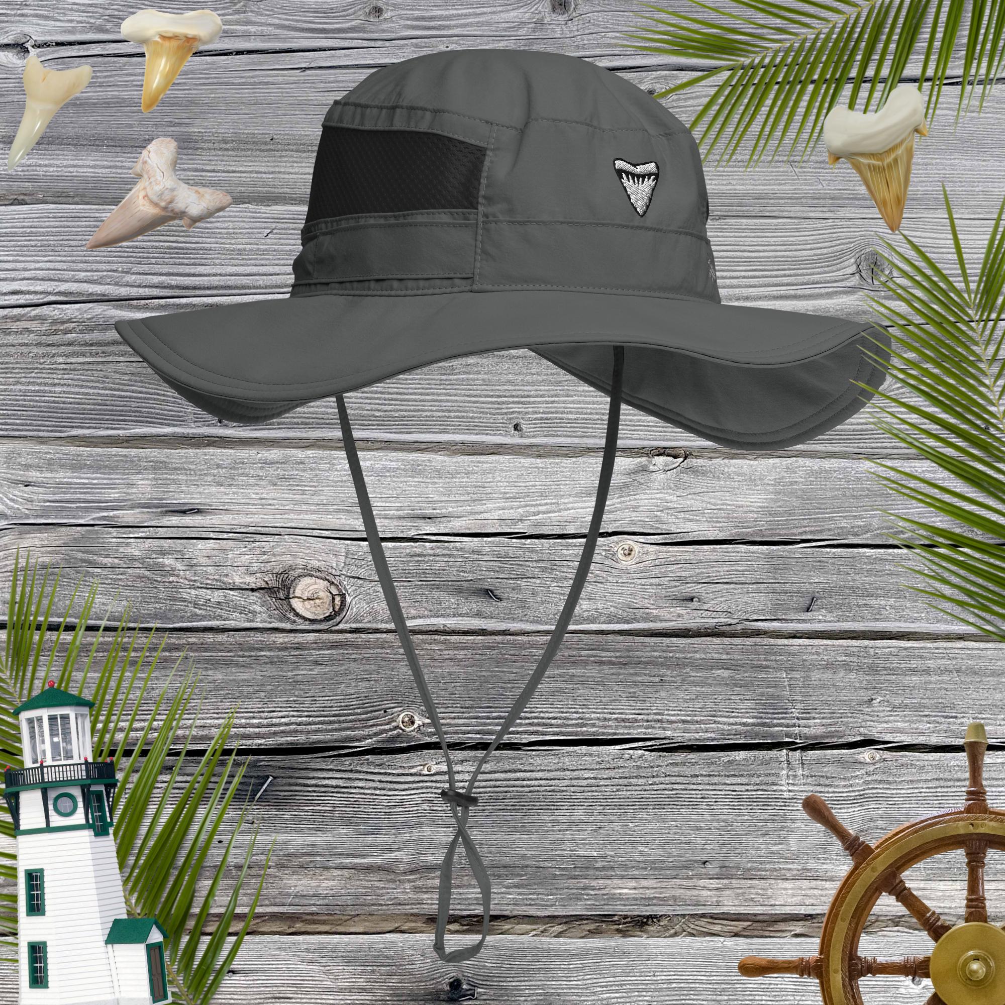 Gray shark tooth sun hat with a chin strap on a wooden background with lighthouse, steering wheel, shark teeth and palm leaves.