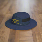 Navy blue hat with 'United States Navy 247th Anniversary' text on a wood floor