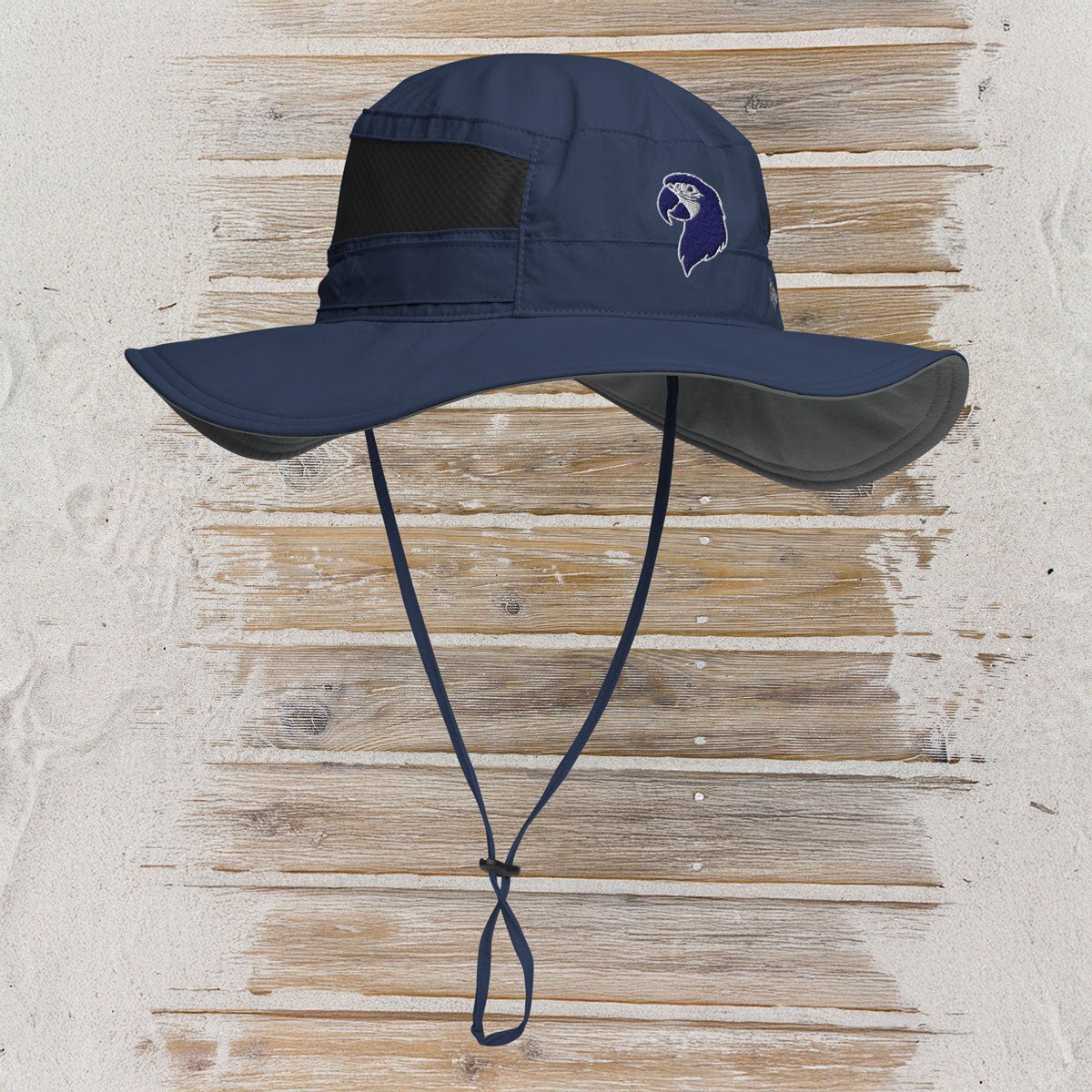 Navy blue sun hat with a logo on a wooden surface