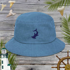 Blue denim cotton bucket hat with an embroidered shark design on a wooden background with nautical elements.