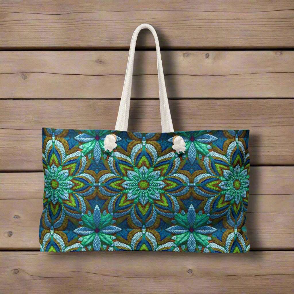 Oversized tote bag that looks like it's been crocheted but is actually a clever  all over art print. hanging from a hook on a rustic wood fishing pier. 