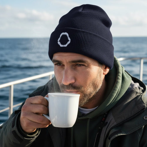 A dark navy blue knit beanie hat featuring a white embroidered shark mouth graphic on the front cuff, shown against a plain white background.