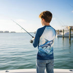Back of Tween dude on a deep sea fishing boat in Destin Marina wearing rashie and blue jean shorts