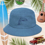 Blue bucket hat with dolphin embroidery on a beach-themed background with surfboard, ukulele, and car.