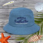 Blue bucket hat with text on a wooden background with fishing gear and beach items.